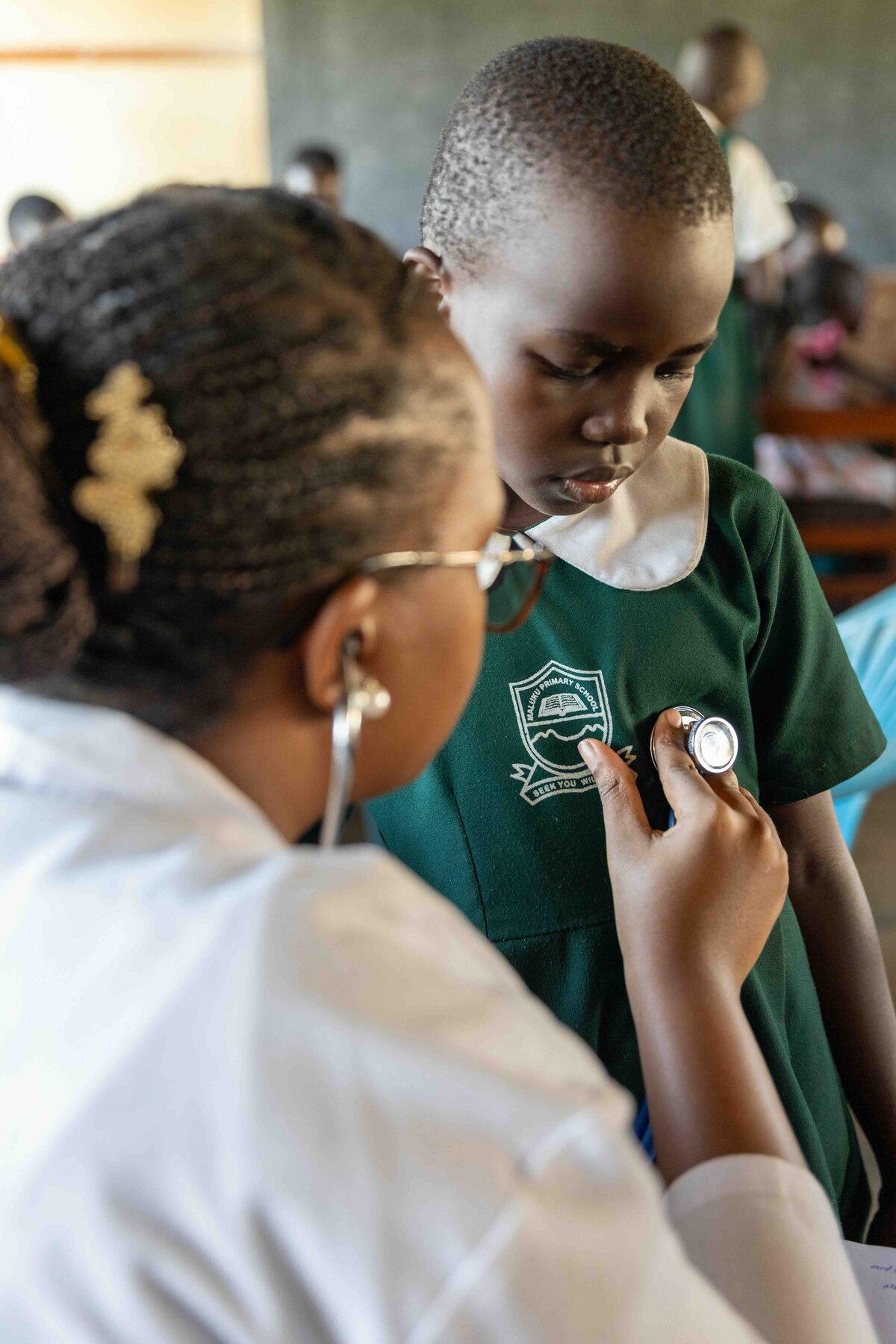 A clinician listens to a pupil’s chest during a school camp